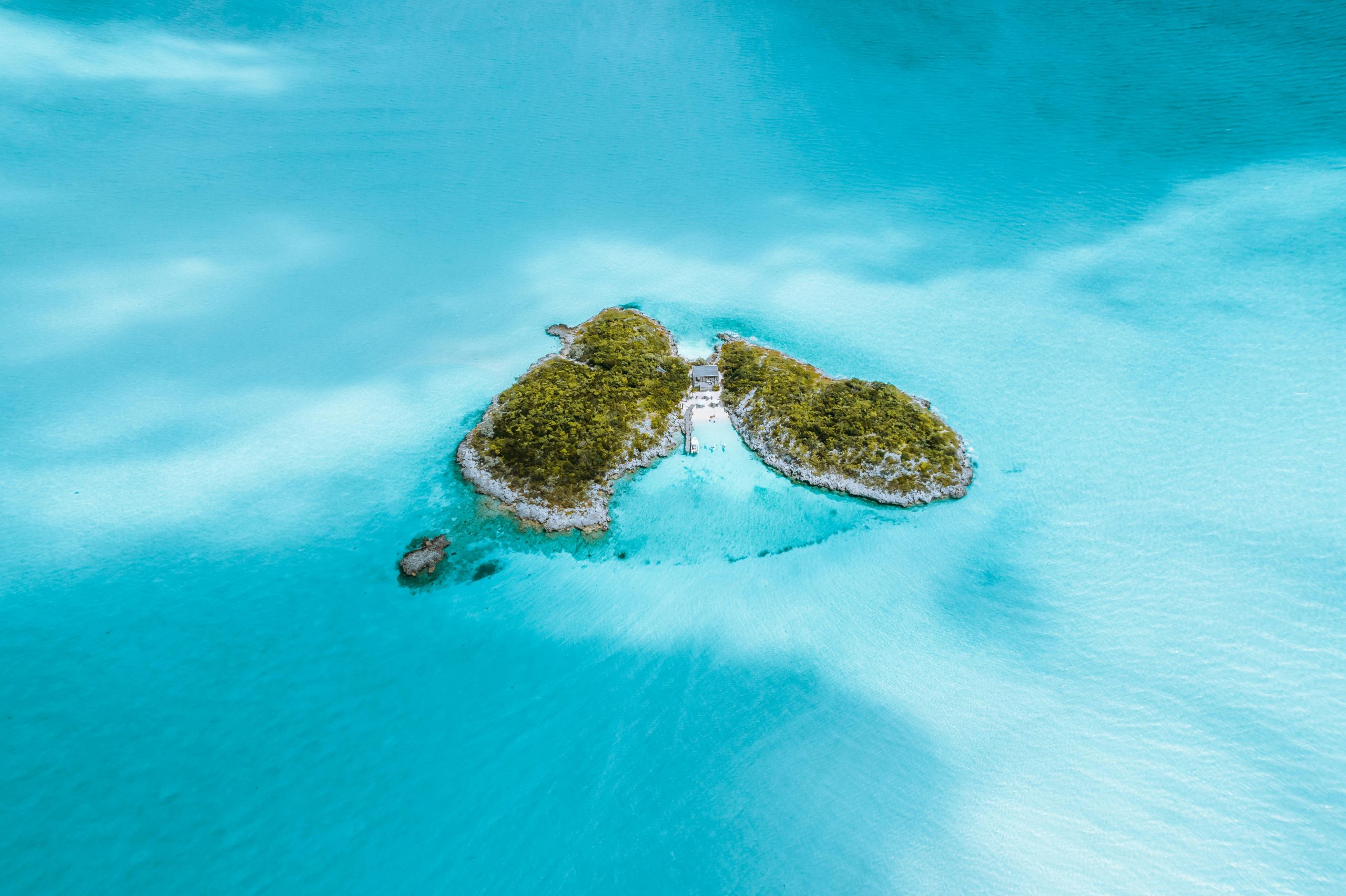 Stunning aerial view of a lush green island surrounded by turquoise ocean waters.